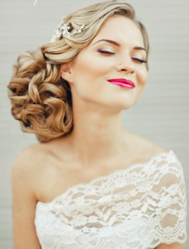 An exquisite wavy low updo with side parting and a rhinestone hairpiece done on long hair is a beautiful idea with a slight vintage feel