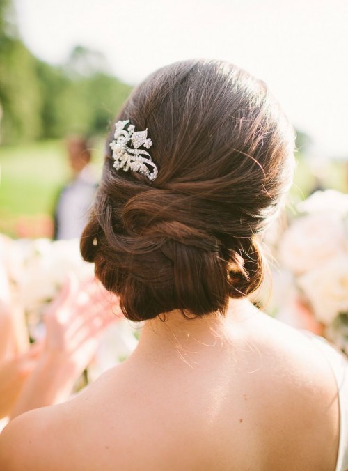 a sleek and twisted low updo accented with a single rhinestone hairpiece is a lovely idea for a formal wedding