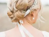 a chic tight and twisted updo with locks framing the face and a rhinestone headpiece with ribbon is a lovely idea for a sophisticated formal bridal look