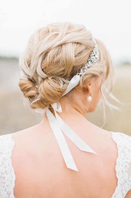 a chic tight and twisted updo with locks framing the face and a rhinestone headpiece with ribbon is a lovely idea for a sophisticated formal bridal look