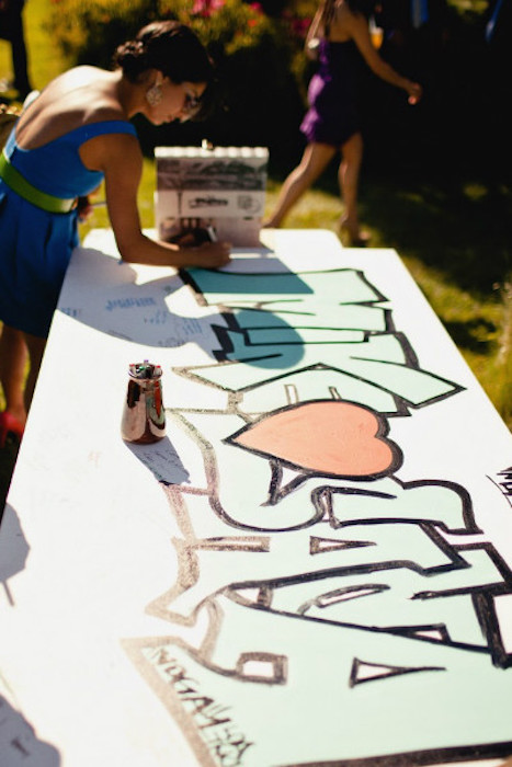 a wedding guest book done with colorful graffiti is a cool and bold idea for a modern wedding and it feels like something super creative