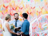 a colorful graffiti-inspired wedding backdrop is a fun and cool idea for a modern wedding, and the combo of colors used is striking