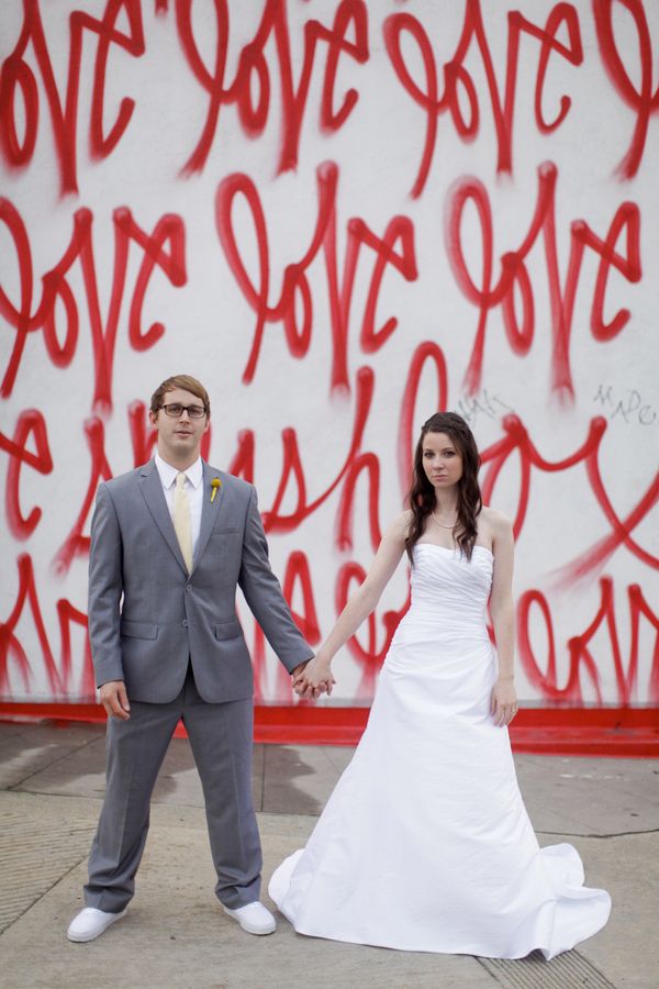 a bold graffiti wall with red letters is a gorgeous idea for a modern and bold look, for taking bridal portraits