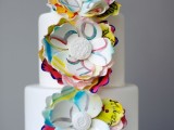 a white buttercream wedding cake with super colorful paper flowers is a gorgeous idea as these flowers are inspired by graffiti