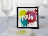 a small and cool graffiti-inspired wedding table number with super bold splashes is a cool idea for a modern wedding