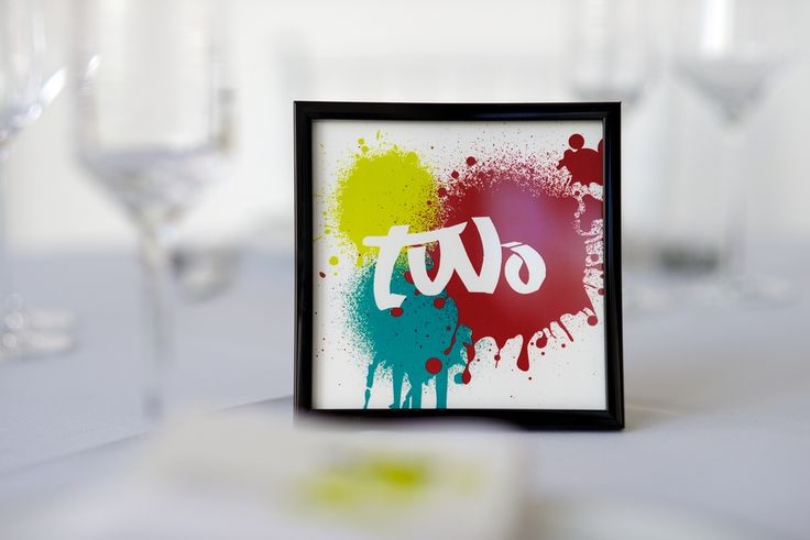 a small and cool graffiti inspired wedding table number with super bold splashes is a cool idea for a modern wedding