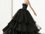 a modern plain black wedding ballown with a strapless bodice and a layered skirt with lots of ruffles for a modern Halloween bride