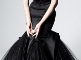 a glossy black strapless mermaid wedding dress with a pointed and bow bodice and a skirt with much tulle is fantastic