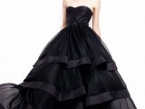a modern black strapless wedding ballgown with an embellished sash and a tiered ruffle skirt is a very bold and refined idea
