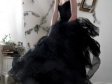 a black strapless wedding ballgown with an embellished bodice and a tiered ruffle skirt is a very glam and chic idea