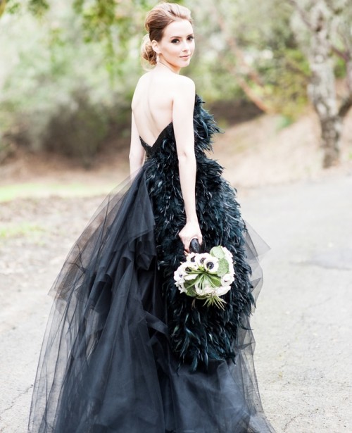 a black strapless wedding ballgown with a feathered bodice, an open back and a tiered tulle skirt is very chic