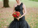 a black one shoulder Halloween wedding dress with a tiered bodice and a tiered skirt is elegant