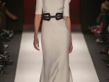 a modern yet Victorian-inspired wedding dress in a neutral tone, with a high neckline, short sleeves and a leather belt to accent the waist
