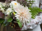 a dimensional wedding bouquet with greenery, white and blush blooms, herbs, berries and twigs looks very forest-like