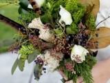 a woodland wedding bouquet of greenery, ferns, berries, white blooms, feathers and large foliage is a bold idea