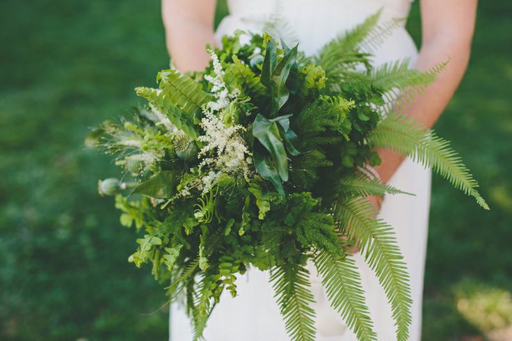 An airy dimensional wedding bouquet of various types of greenery, pink blooms and herbs for a spring or summer forest bride