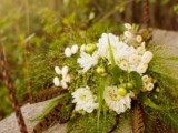 a greenery wedding bouquet with white blooms, berries and feathers is great for summer or fall woodland weddings
