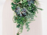 a cascading wedding bouquet of various types of succulents and some vines going down is great for a woodland wedding