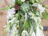 a bold cascading wedding bouquet of various types of greenery, a succulent, white orchids and lotus is great for a woodland wedding