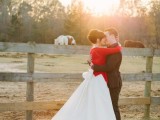 a romantic wedding dress with a large bow on the back and a train plus a red cardigan for a Christmas wedding
