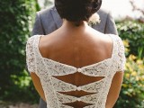 a fitting wedding gown with a lace bodice, cap sleeves and a catchy cutout back on buttons and a plain skirt