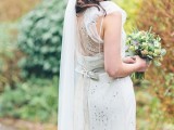a chic fitting embellished wedding dress with an illusion back, a sash, a long veil for a glam bridal look