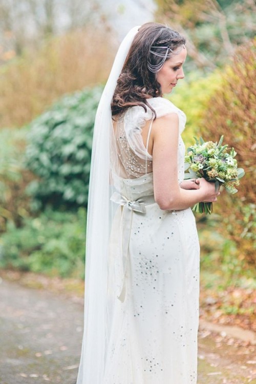 a chic fitting embellished wedding dress with an illusion back, a sash, a long veil for a glam bridal look