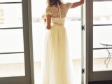 a vintage-inspired wedding dress with an embellished bodice, an illusion back, short sleeves and a tulle skirt