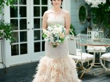 a glam strapless mermaid wedding dress with a feather skirt and an embellished bodice