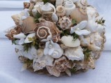 a rough wedding bouquet of seashells, pearls, greenery, white fabric blooms shaped as a ball