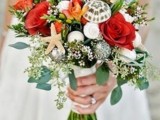 a bold coral wedding bouquet spruced up with neutral and white seashells plus greenery
