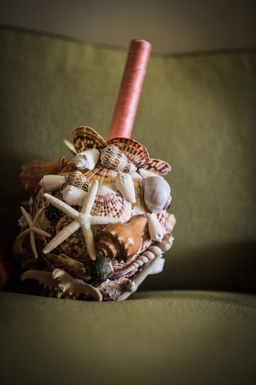 a seashell wedding bouquet with starfish and a pink wrap is a styish and chic idea