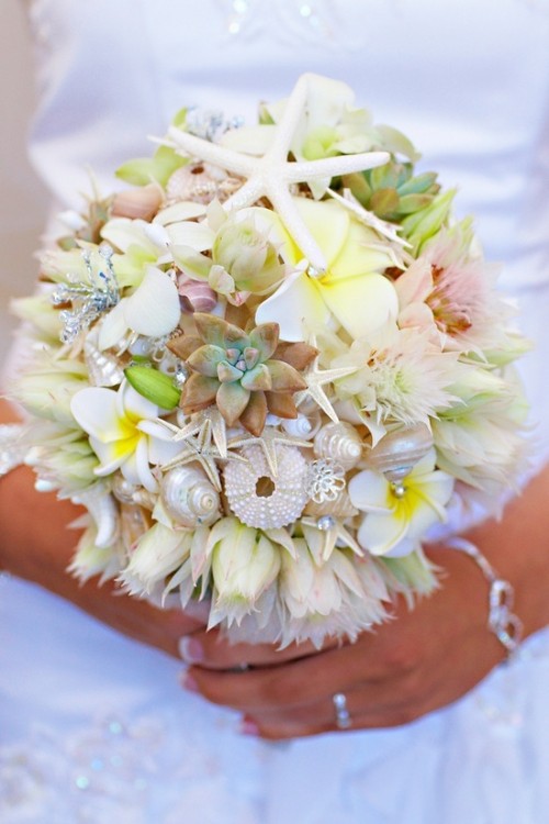 a neutral beach wedding bouquet dotted with pastel blooms, succulents, seashells and sea urchins plus some greenery
