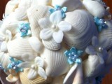 a beach wedding bouquet with seashells, white and blue fabric flowers, pearls and beads