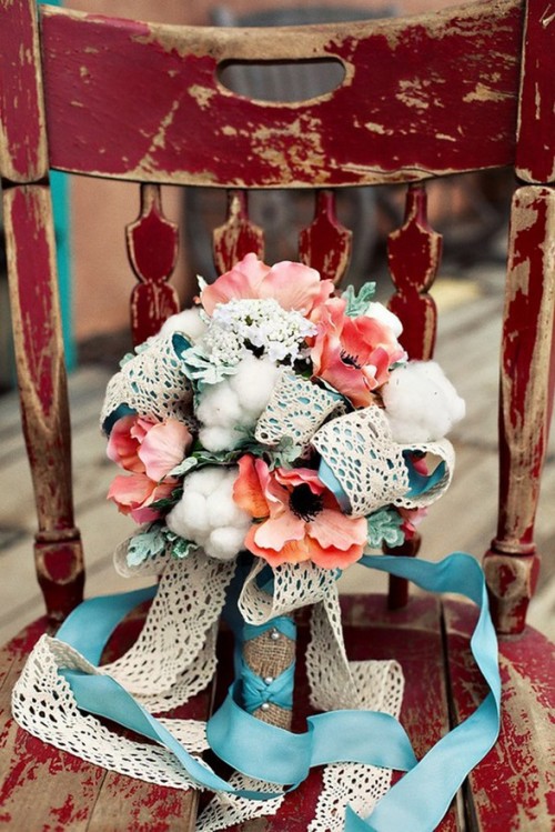 a bouquet of bright coral blooms, cotton, blue and lace ribbons for a bright beach wedding