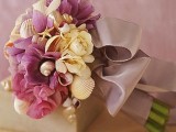a pink and neutral wedding bouquet with seashells and a dusty pink ribbon for wrapping the bouquet