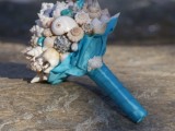 a beach wedding bouquet made completely of shells and a blue wrap for a colorful touch