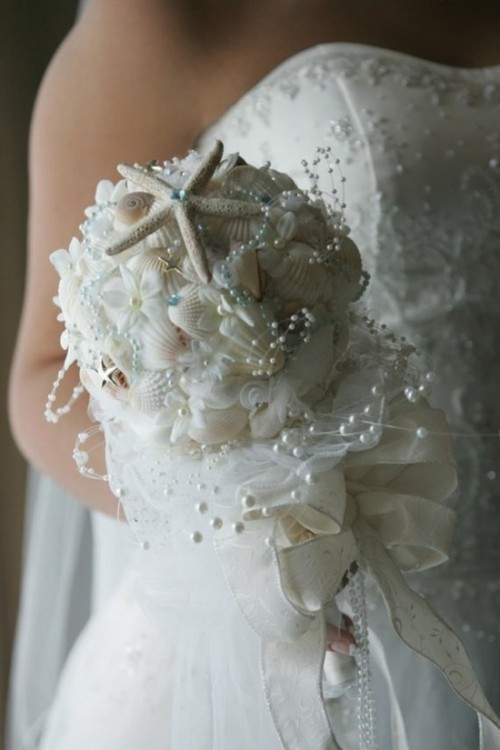 a white beach wedding bouquet of seashells, starfish, pearls and fabric flowers all over