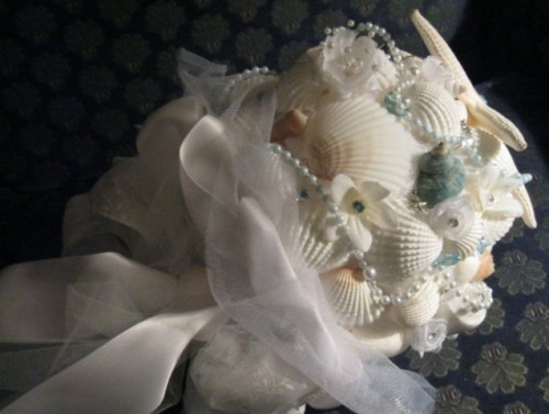 a neutral shell wedding bouquet and pearls plus ribbons and feathers