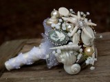 a neutrla beach wedding bouquet composed of brooches, pearls, baby’s breath and ribbons