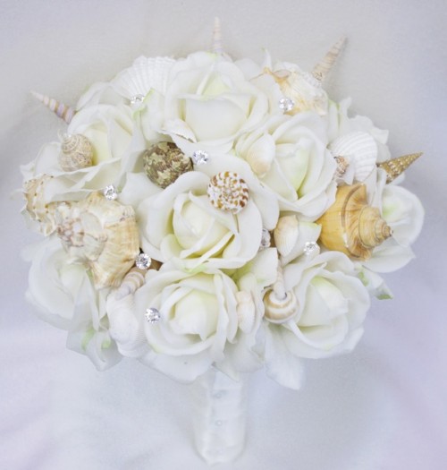 a neutral beach wedding bouquet of white blooms, shells and rhinestones will sparkle at the wedding