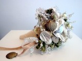 a beach wedding bouquet of seashells, beads and pearls, greenery and pink ribbons