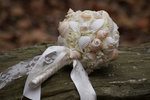 a blush and white ball wedding bouquet fully made of seashells