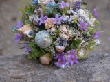 a bright beach wedding bouquet with purple and blue blooms, greenery and neutral and blue shells