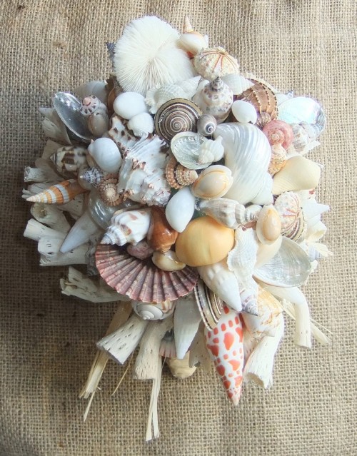 a neutral beach wedding bouquet of seashells, starfish and other sea-inspired stuff