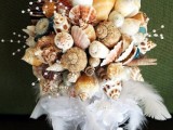 a neutral wedidng bouquet of seashells, pearls, feathers and a white ribbon wrap