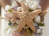 a unique beach wedding bouquet of seashells, sea urchins and star fish, some white blooms nd greenery
