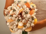 a beach wedding bouquet of yellow, neutral and mother of pearl shells plus fabric flowers
