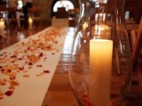 a fall wedding aisle covered with orange and burgundy petals, with candle lanterns along it is a pretty idea to rock
