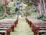a pretty fall wedding aisle with bold leafy arrangements in copper buckets is a pretty solution for the fall